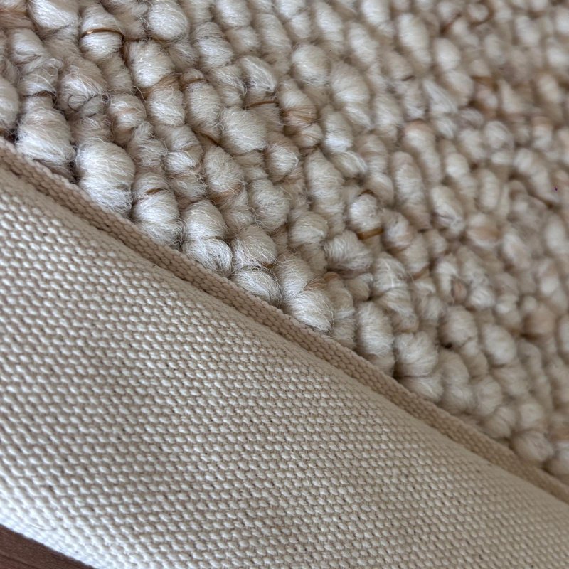 Tapis de salon sur mesure beige clair effet laine bouclée finition gansée