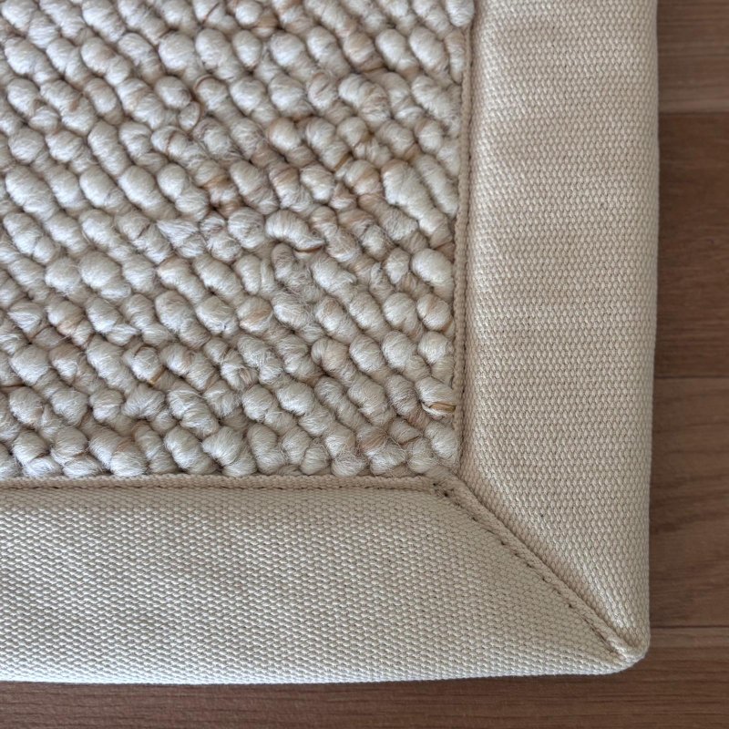 Tapis de salon sur mesure beige clair effet laine bouclée finition gansée