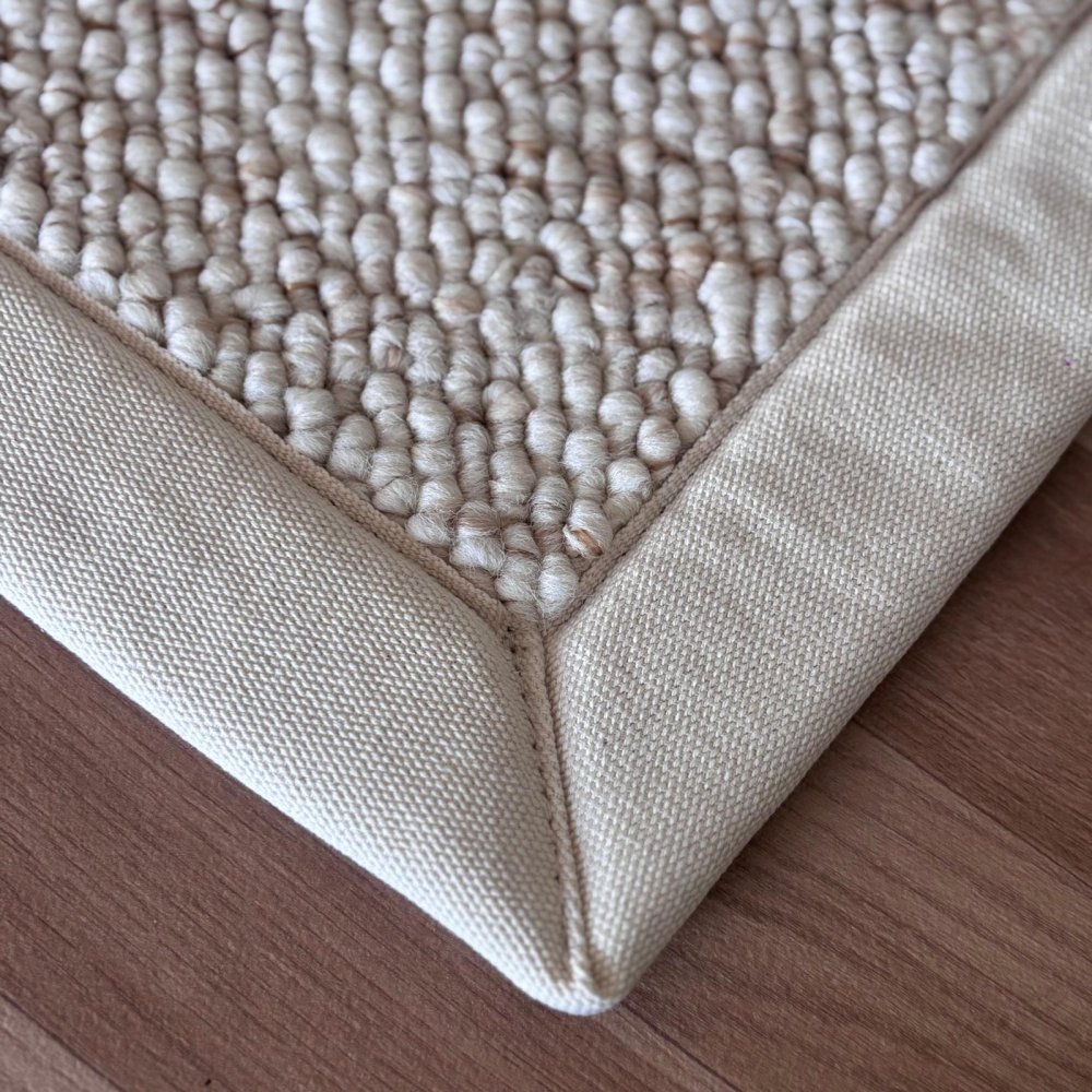 Tapis de salon sur mesure beige clair effet laine bouclée finition gansée